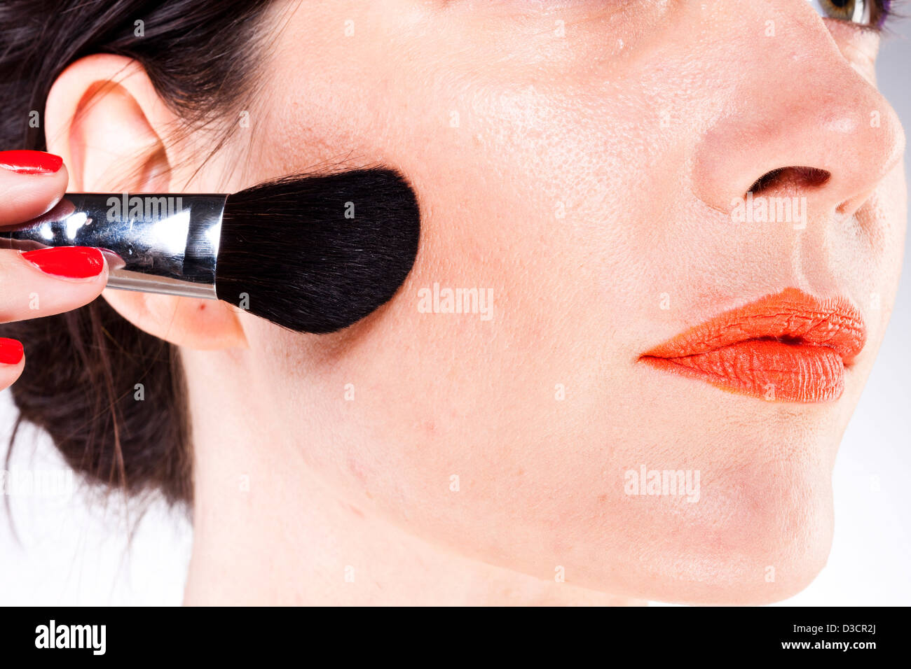 Woman applying blusher with blusher brush Stock Photo