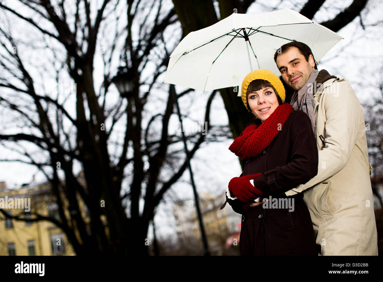 Young couple in the park on the rainy day Stock Photo - Alamy