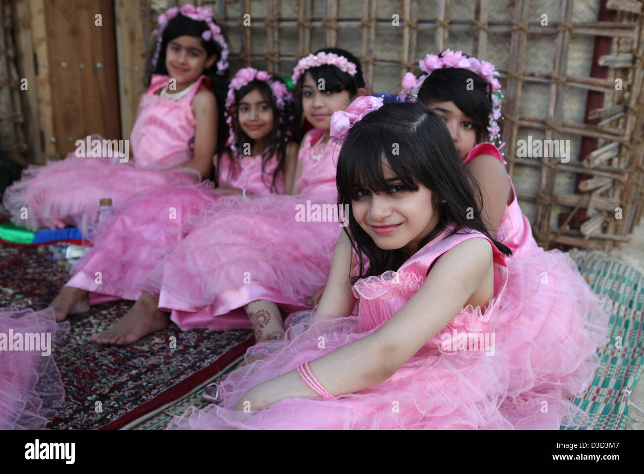 Dubai, United Arab Emirates, girls in pink dresses sitting on the floor Stock Photo