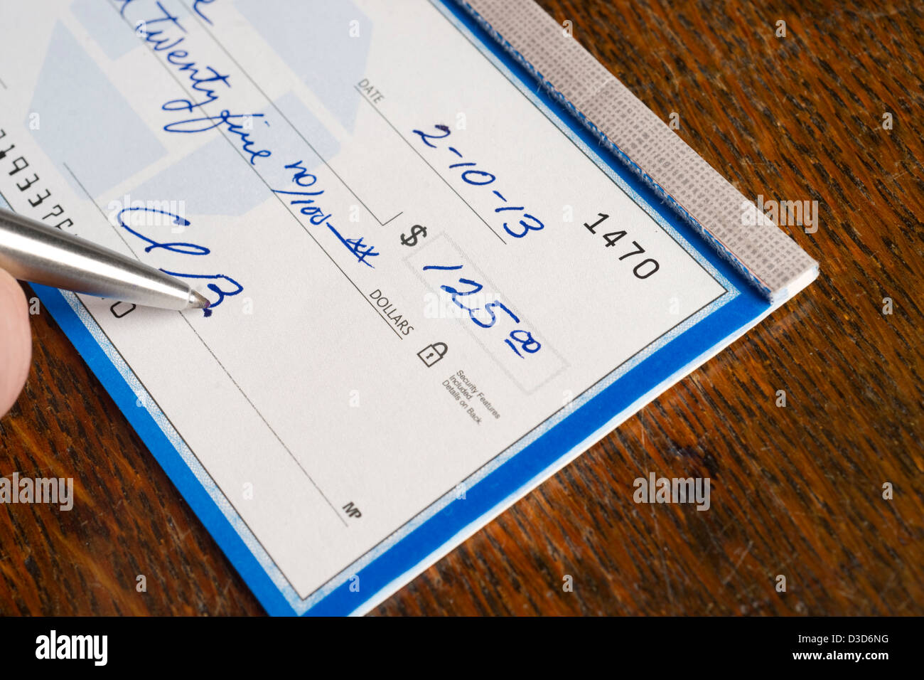 A Check is signed in ballpoint pen on the desk Stock Photo