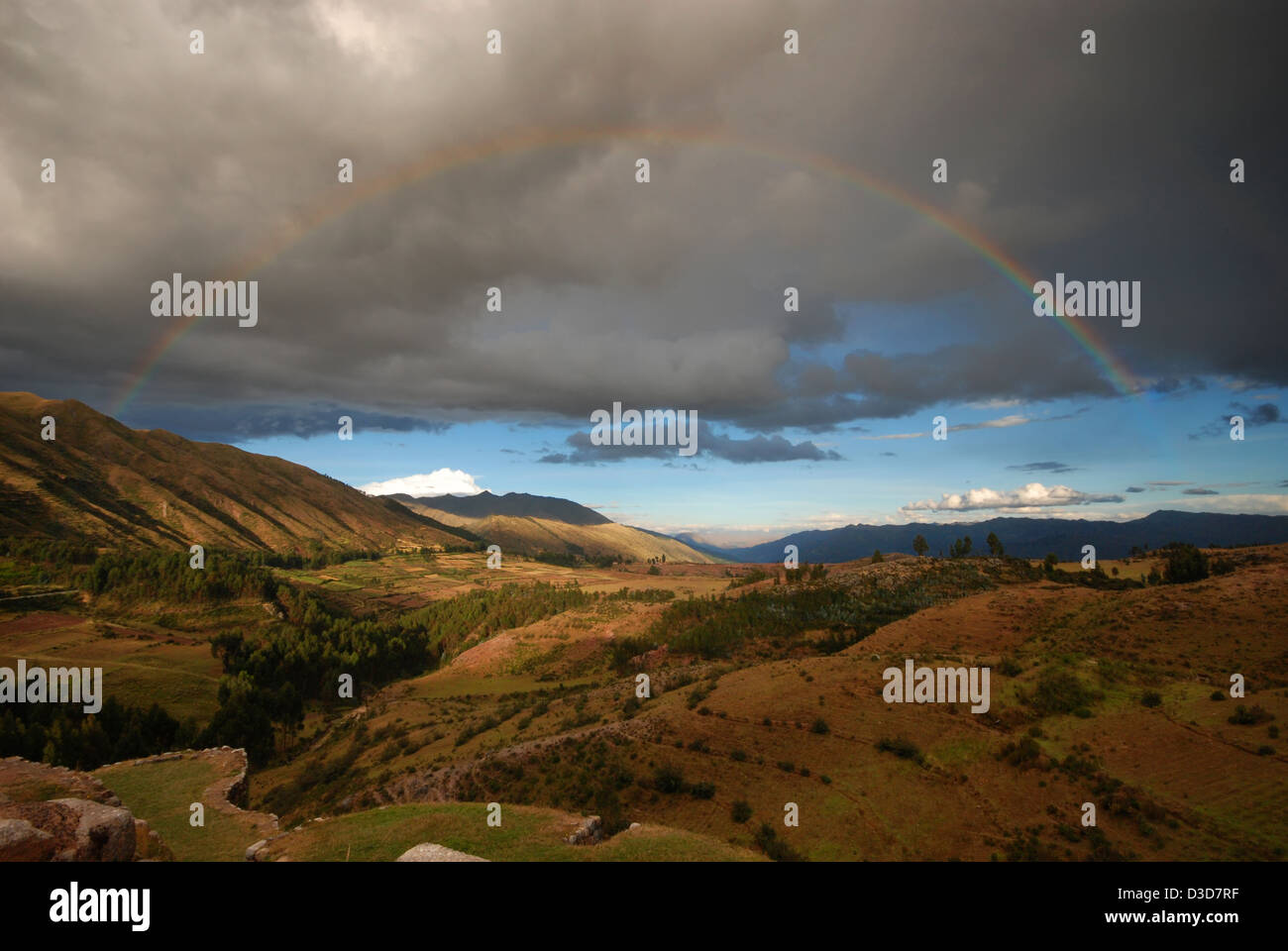 Andean landscape, with passing storm clouds and a rainbow over the hills Stock Photo