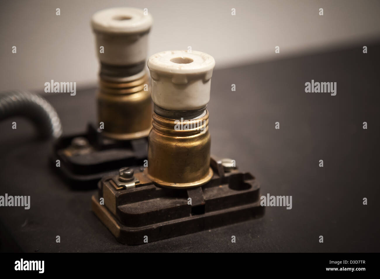 Two vintage electrical fuses on dark panel Stock Photo
