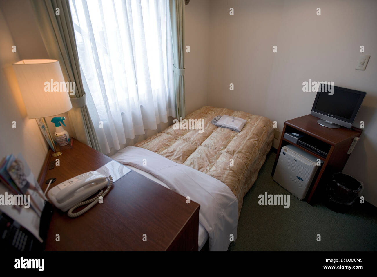 Clean, neat and tidy, a single room at a Japanese business hotel is small by Western standards but very inexpensive and safe. Stock Photo