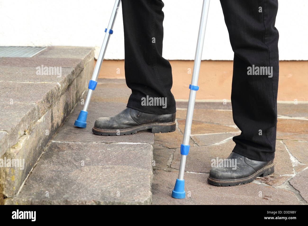 Person with crutches climbing stairs Stock Photo Alamy