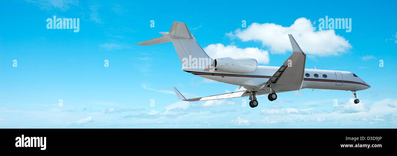 Private jet aircraft in flight. Panoramic composition. Stock Photo