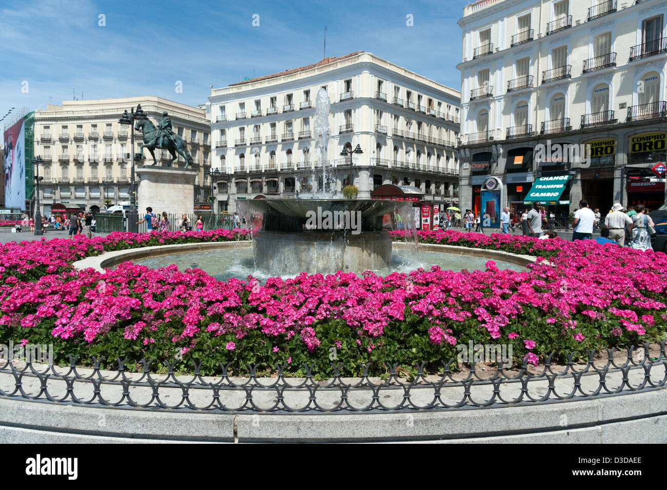 Flowerbed of pink geraniums around water fountain in the Puerta del Sol, Madrid, Spain Stock Photo