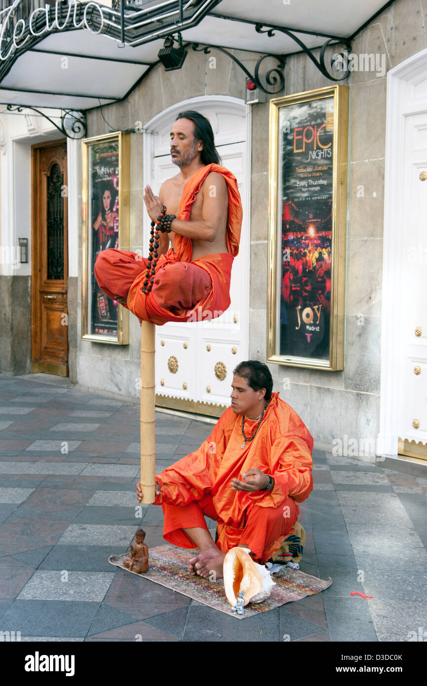 Buddhist street entertainers performing a levitating illusion on Calle Arenal, Madrid, Spain Stock Photo