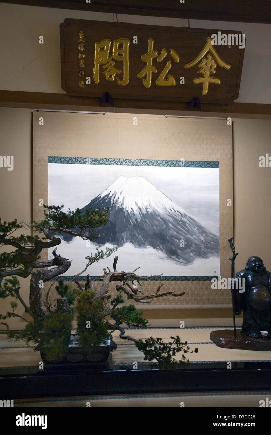 Tokonoma display of Mt. Fuji scroll, bonsai tree and Buddha statue of Hotei in zazen Sanshokaku Hall of Soto sect Eiheiji Temple Stock Photo