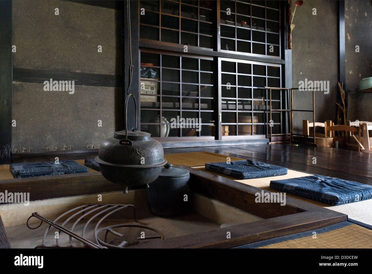 Traditional irori sunken hearth fire pit with kettle in historic