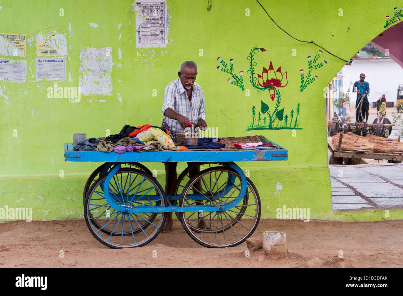 Traditional Indian street laundry man (dhobi) ironing washed clothes on