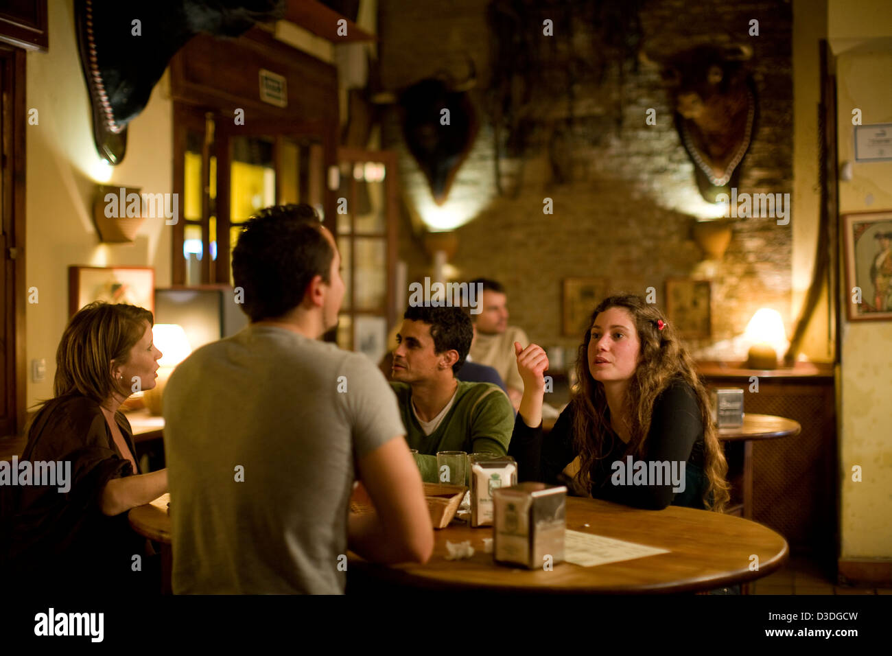 SEVILLE, SPAIN, 21st FEBRUARY 2008: Young people enjoy an evening out at  Casa Pepe Hillo tapas bar near the Seville bull ring. The heads of bulls  killed in the ring hang on