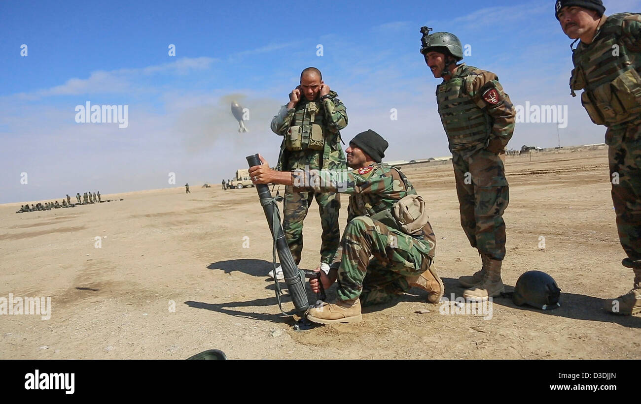 An Afghan commando practices firing a a 60mm mortar during weapons practice on a firing range February 16, 2013 in Helmand province, Afghanistan. Afghan commandos are mentored by US Special Forces as part of the transition to Afghan control. Stock Photo