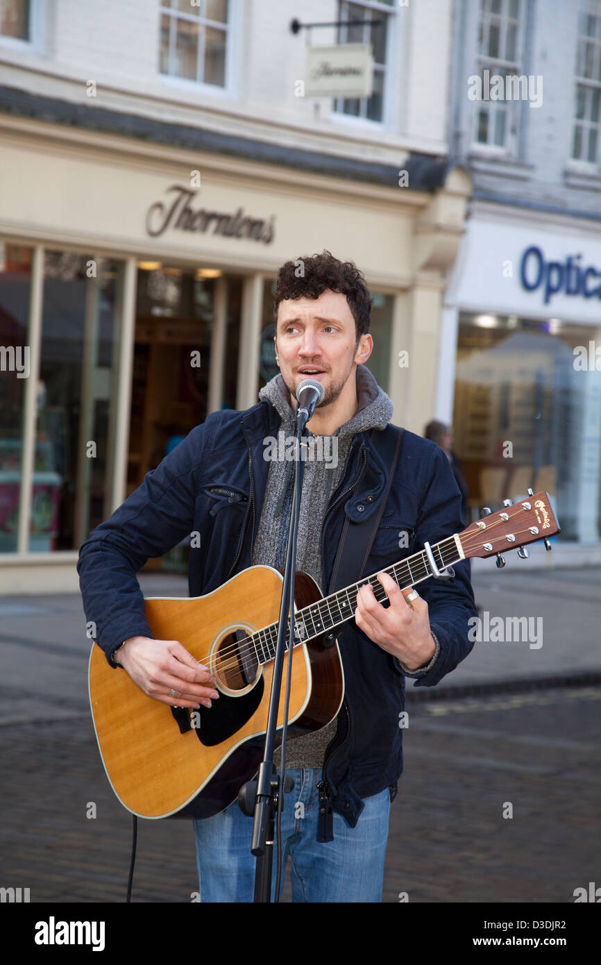 Licenced Buskers  Neil Ryan a musician singing into microphone, busking in the centre of York, Yorkshire, UK Stock Photo