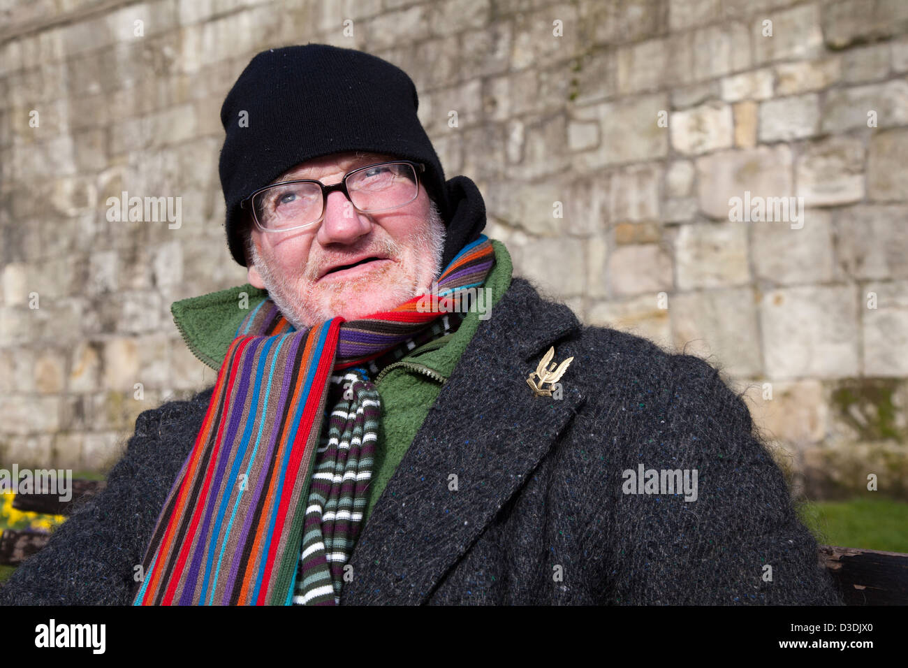 Who Dares Wins badge on old soldier  Homeless person in York, seated pensioner well wrapped up for the winter.  Yorkshire, UK Stock Photo