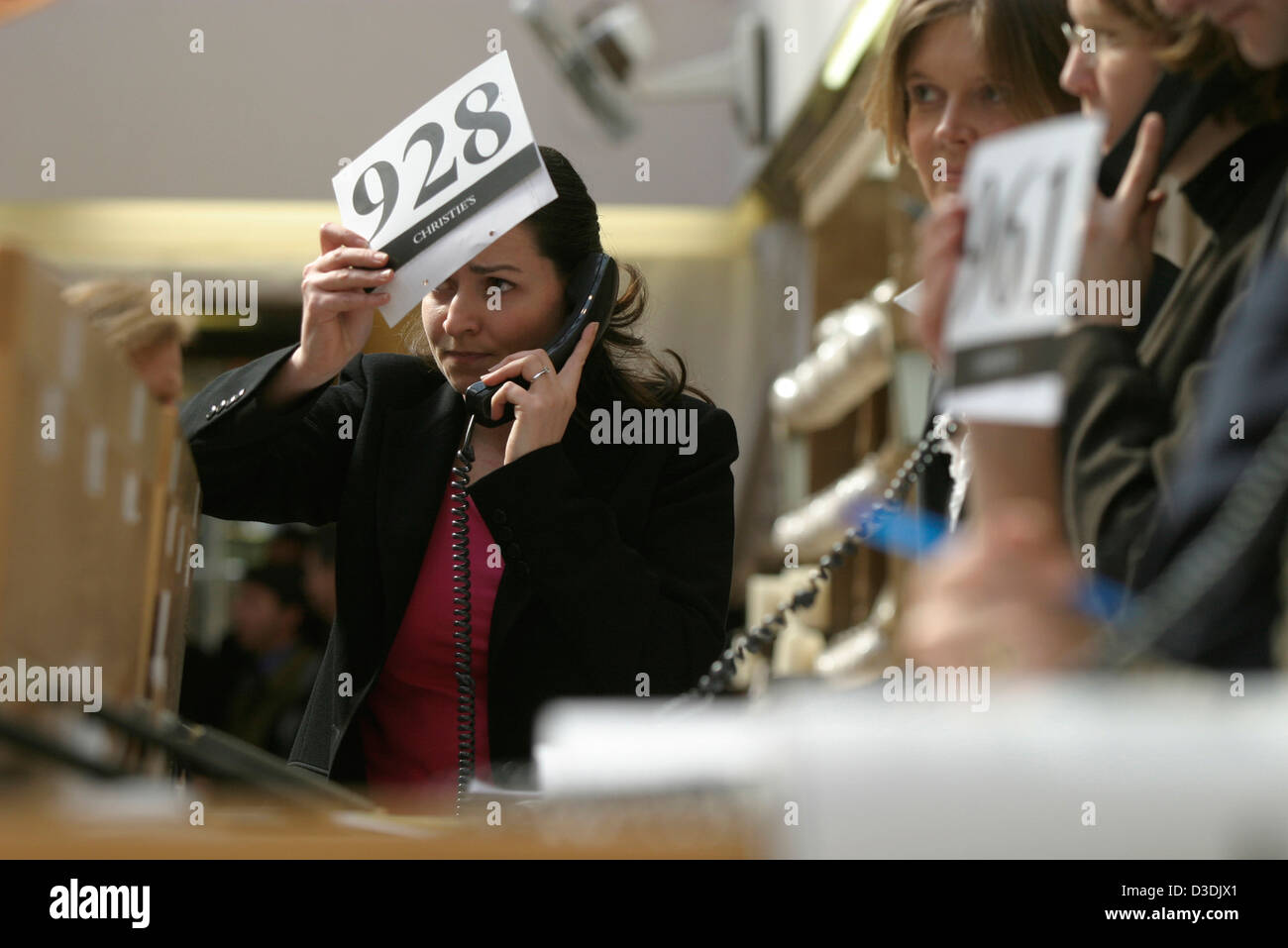 LONDON, ENGLAND - MARCH 2004:  Christie's staff offer a client's telephone bid during a sale of furniture at Christie's auction house, South Kensington. Stock Photo