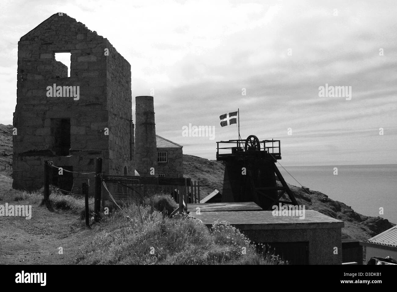 Cornish tin mine by the sea flying the Cornish flag Stock Photo