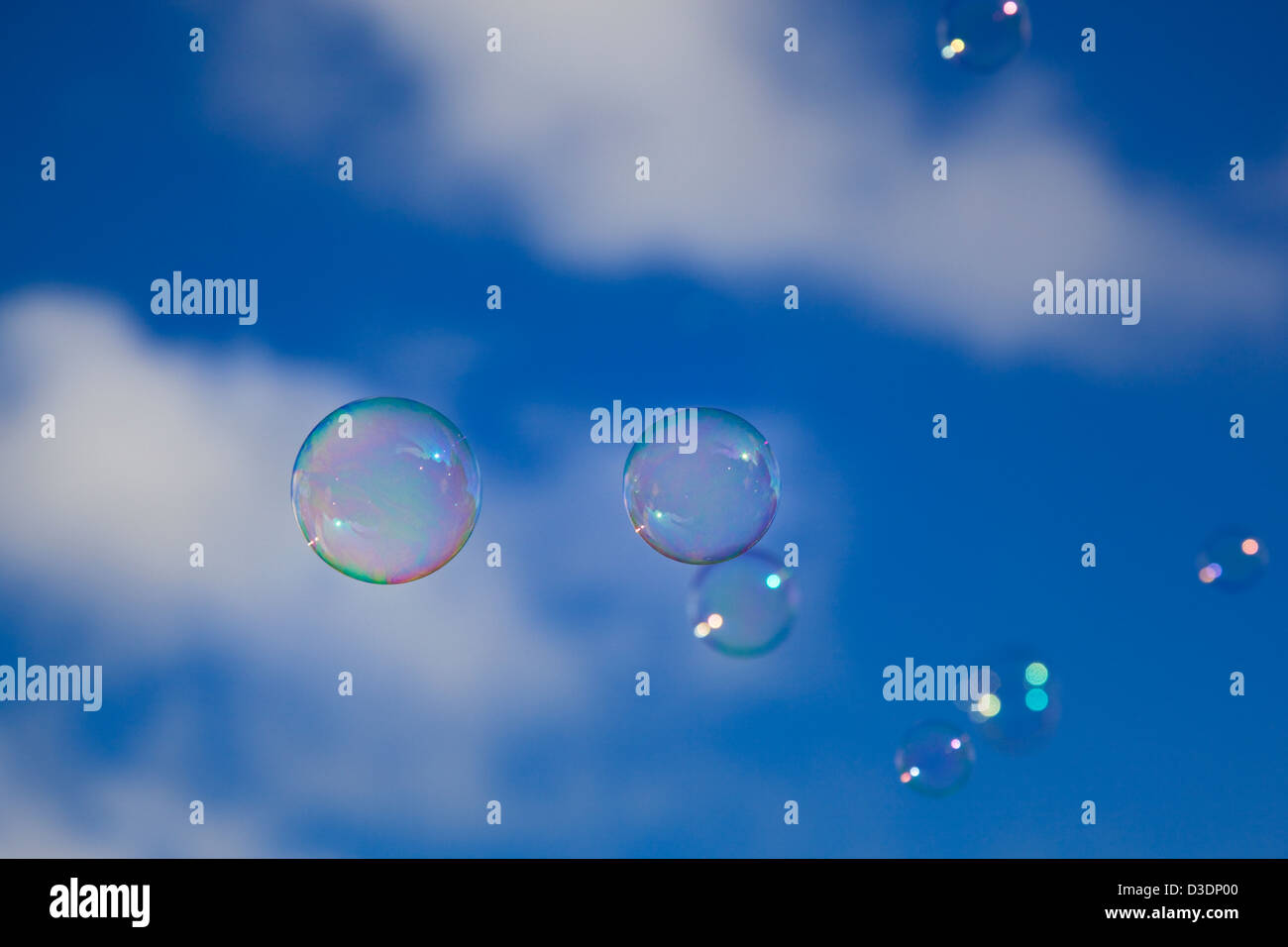 Several bubbles with a cloudy blue sky as background Stock Photo