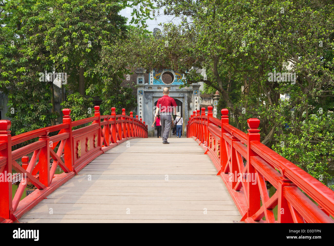 Man walking in Sun Huc Bridge Vietnam, Hanoi, Hoan Kiem Lake . Stock Photo