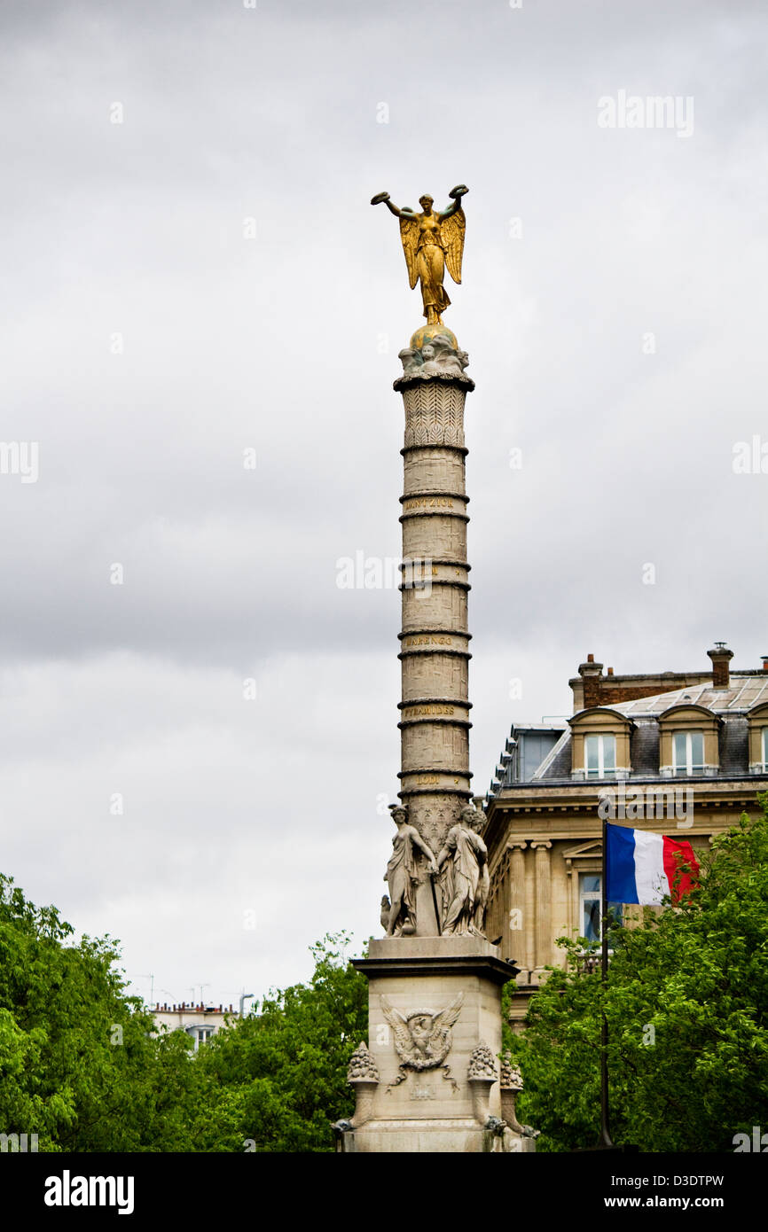 Close view of a tower with a golden statue on the top located in Paris
