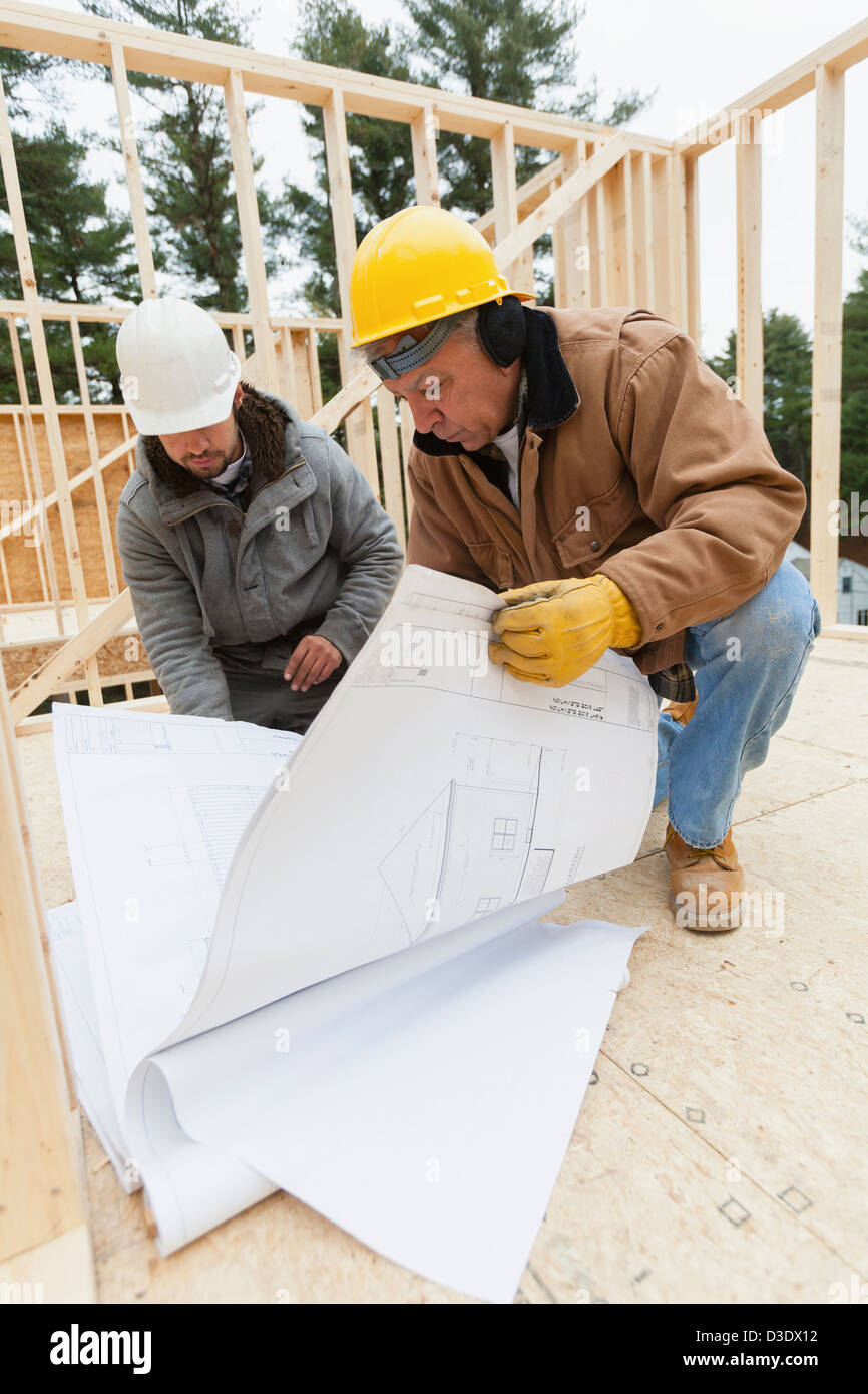 Construction supervisor reviewing home design plan with a carpenter Stock Photo