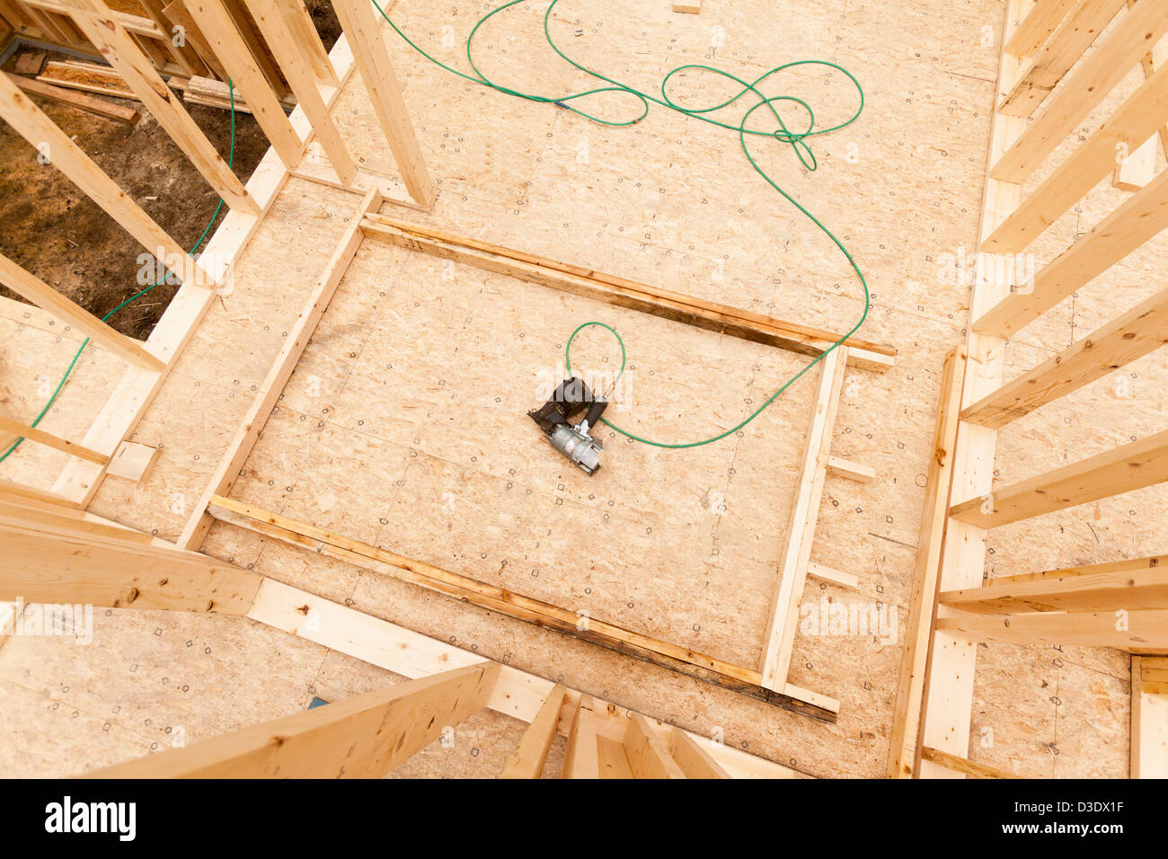 High angle view of a nail gun lying on wall section being assembled
