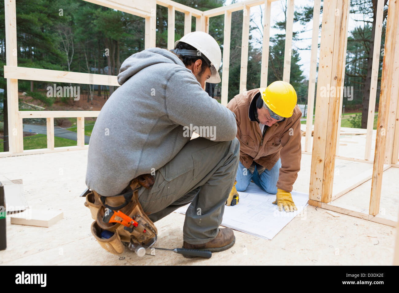 Construction supervisor reviewing home design plan with a carpenter Stock Photo
