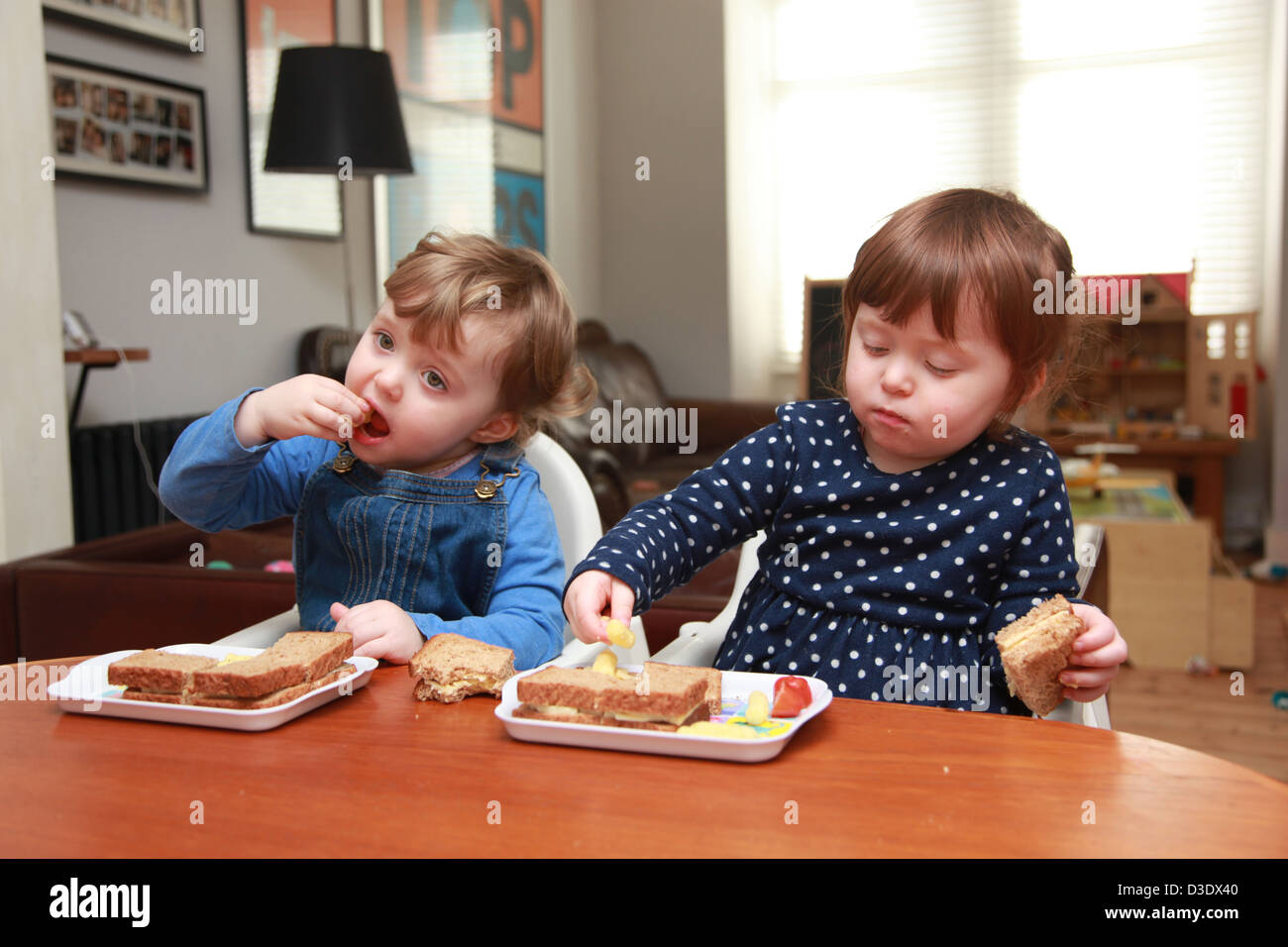 Twin girls eating lunch Stock Photo - Alamy