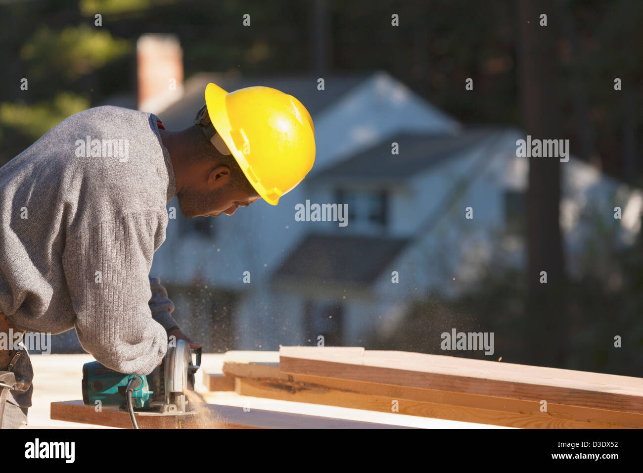 Carpenter cutting bevel on rafter with a circular saw Stock Photo