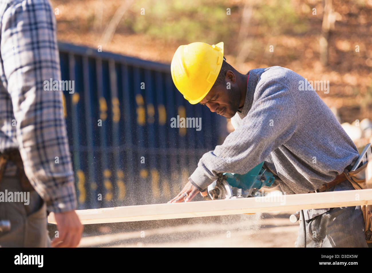 Carpenter using a circular saw to make bevel cut Stock Photo