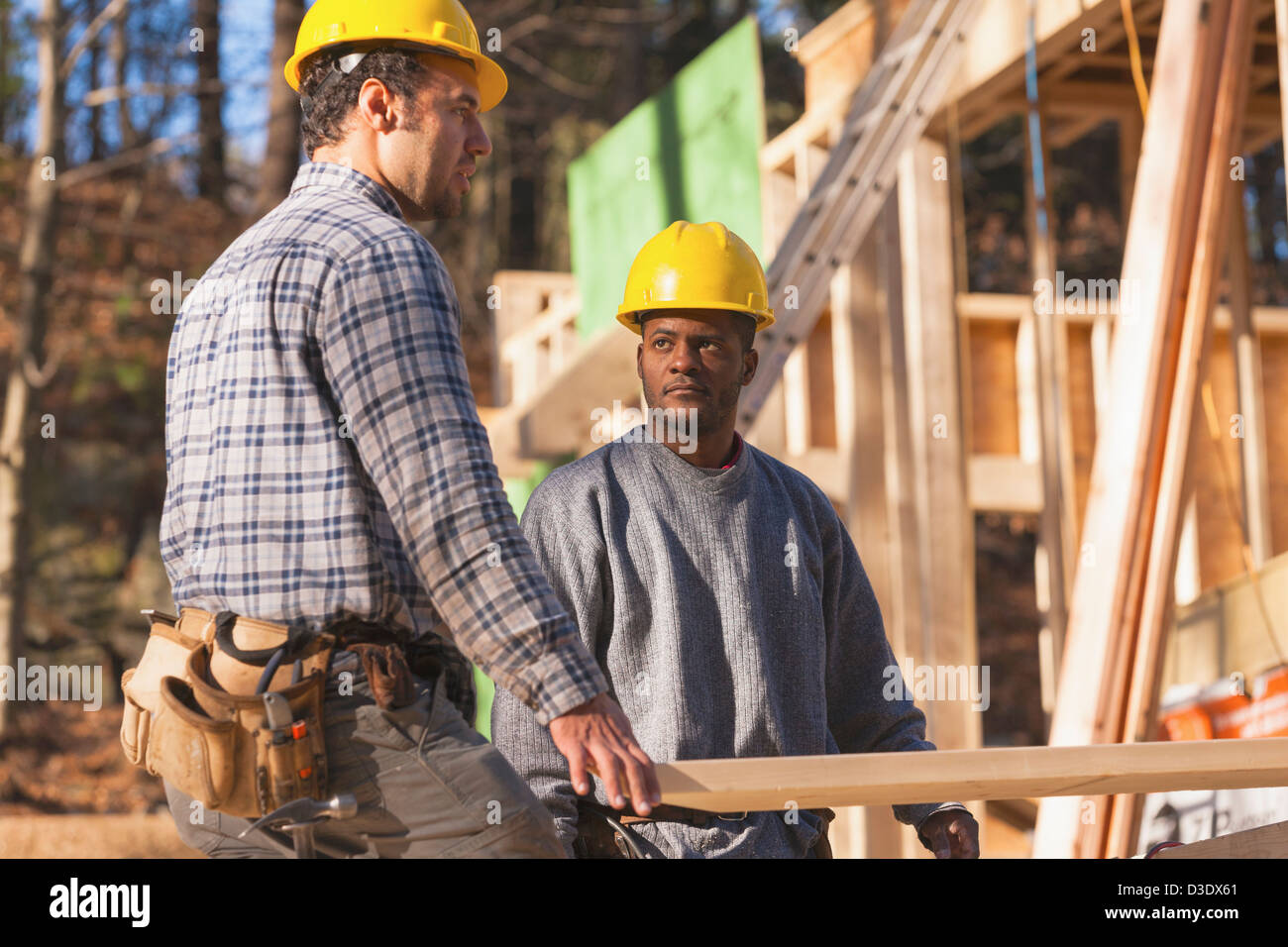 Carpenters moving a rafter Stock Photo