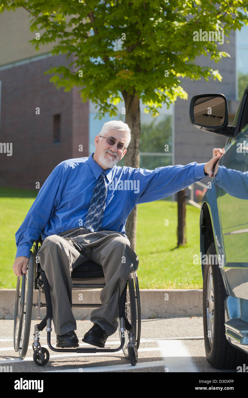 Man with muscular dystrophy and diabetes in a wheelchair beside an