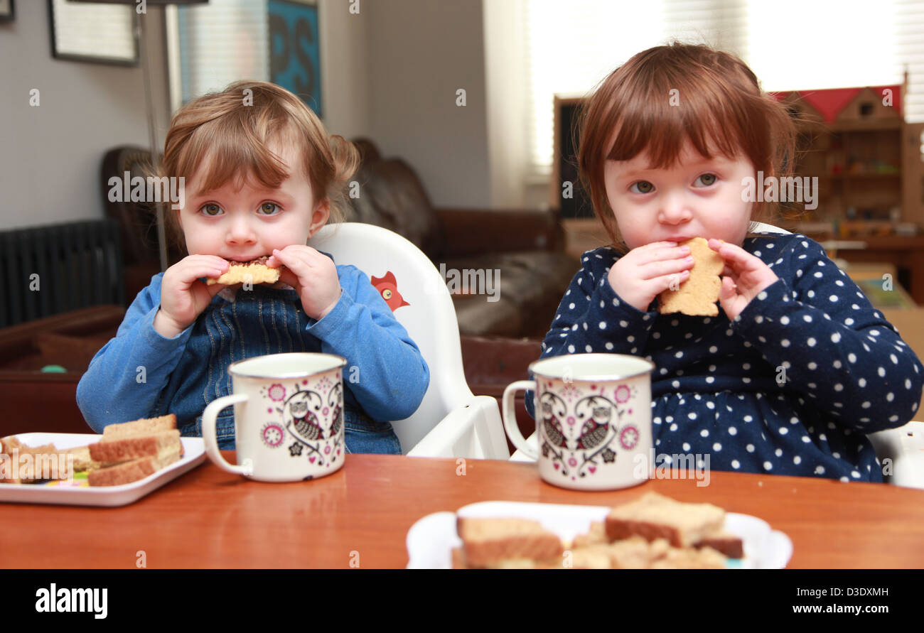 Twin girls eating lunch Stock Photo - Alamy