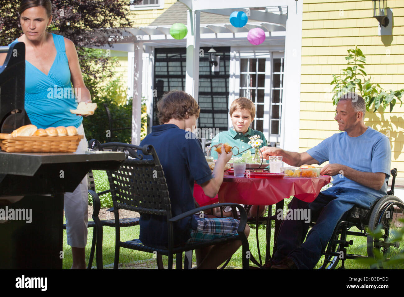 Man with spinal cord injury in wheelchair at family picnic Stock Photo