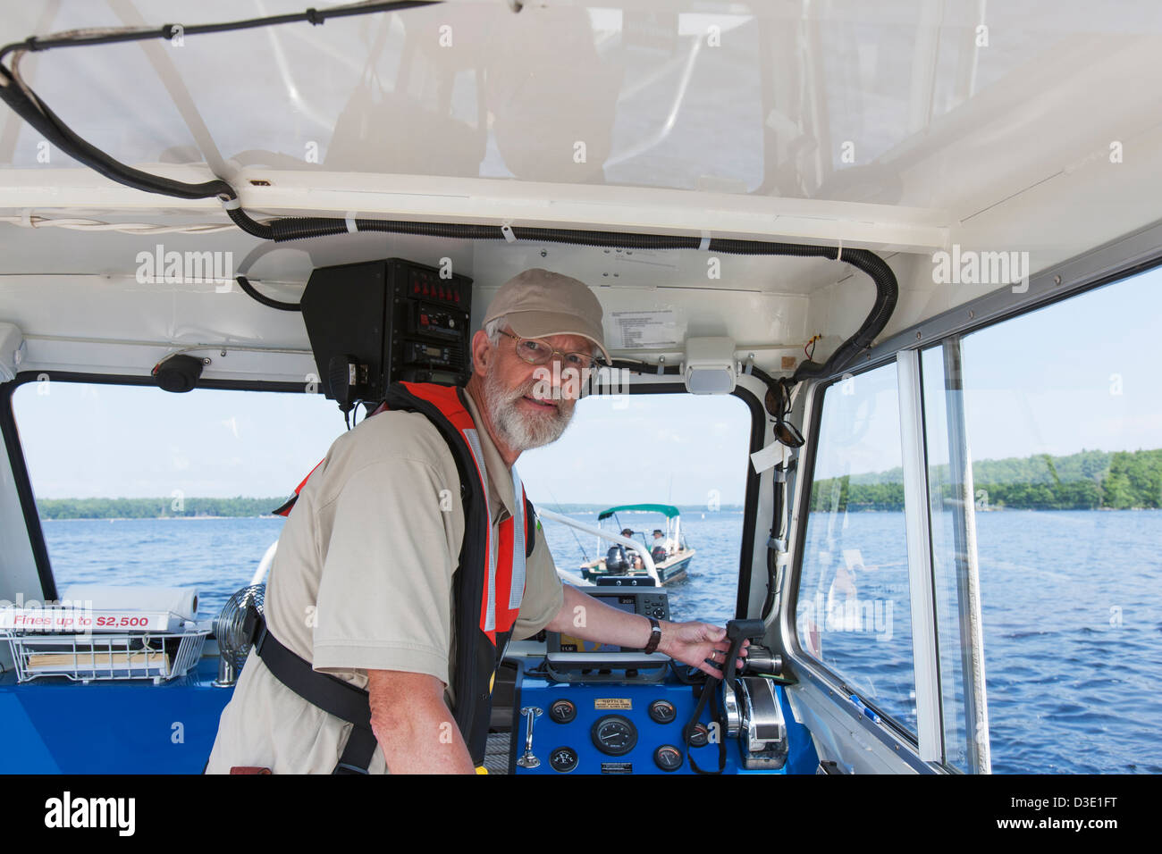 Public works engineer piloting service boat for sampling water on