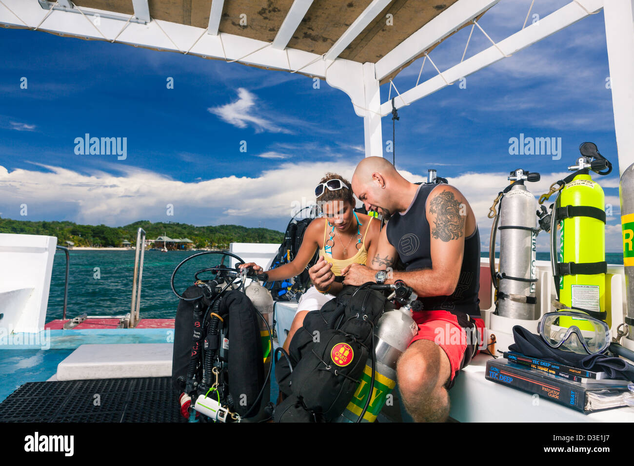 Two scuba divers review dive plan and check technical equipment on boat before starting tec dive. Roatan, Honduras Stock Photo