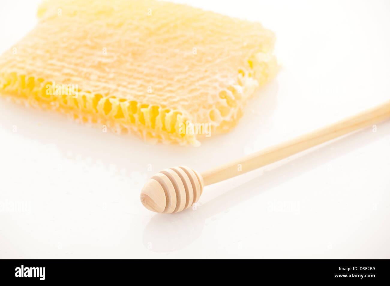 Full honey pot and honey stick over white and honeycomb Stock Photo
