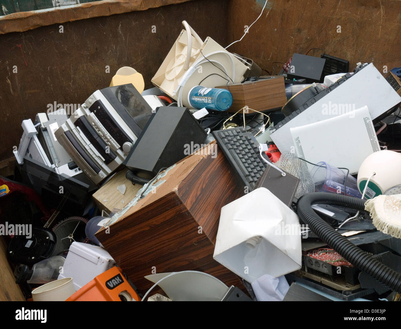 electronic goods in a commercial skip at a recycling center Stock Photo