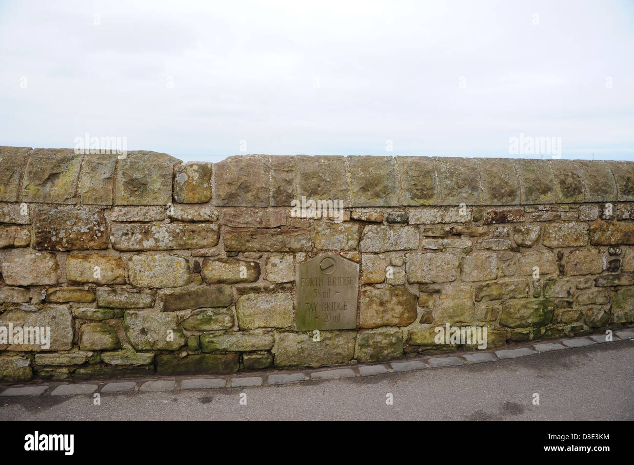 A coastal wall in St Andrews, Scotland, informs of distance to two bridges. Stock Photo