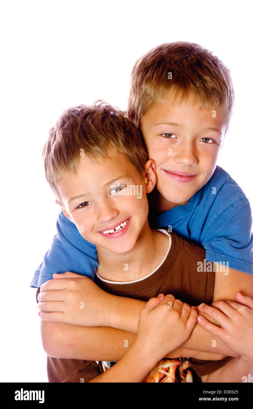 Two young boys hugging each other very happy; isolated on white Stock