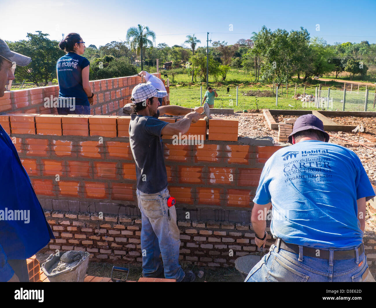 A group of international volunteers and local workers build a house for the needy sponsored by Habitat for Humanity Paraguay. Stock Photo