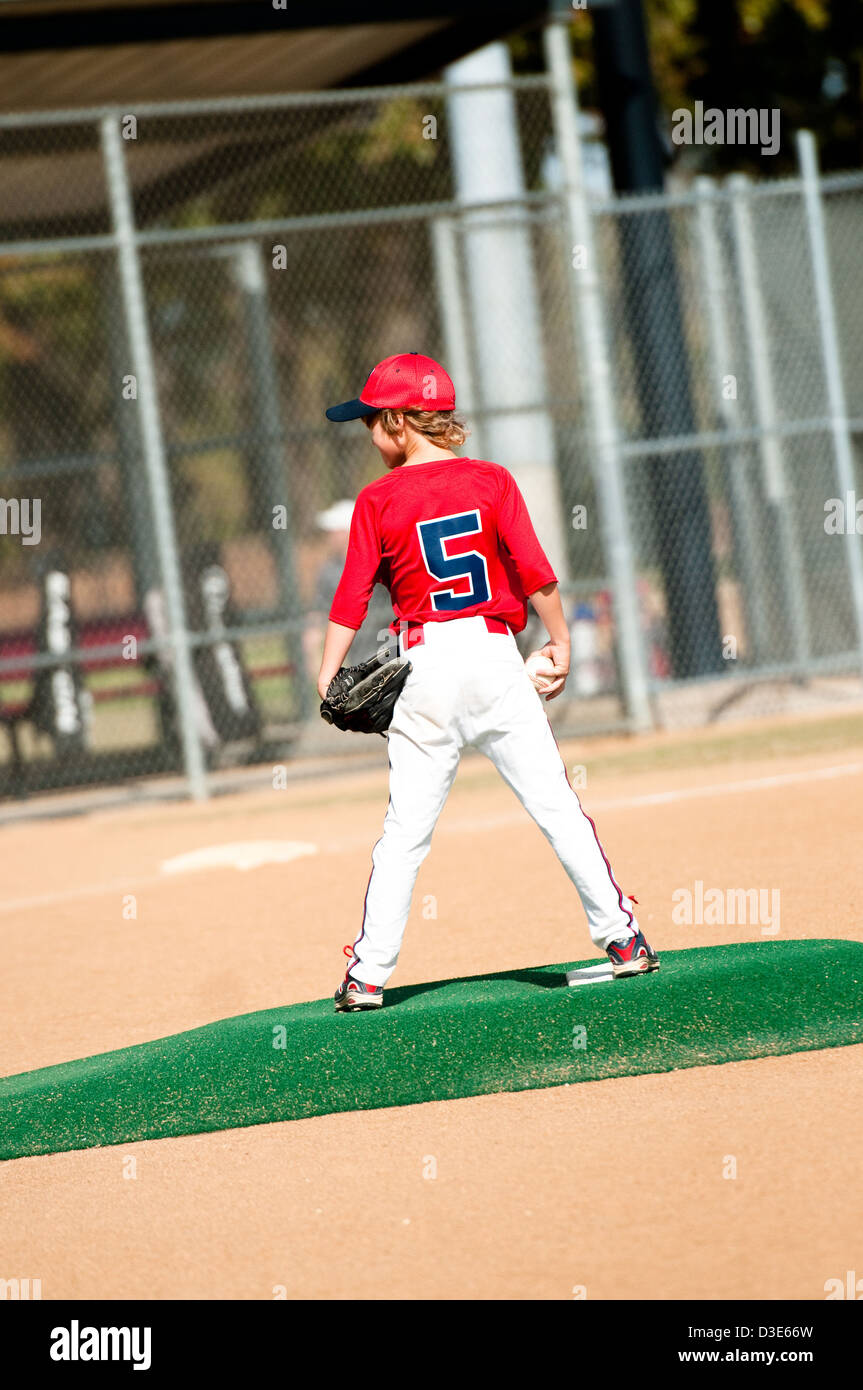 Young boy in red jersey standing on pitching mound about to pitch. Stock Photo