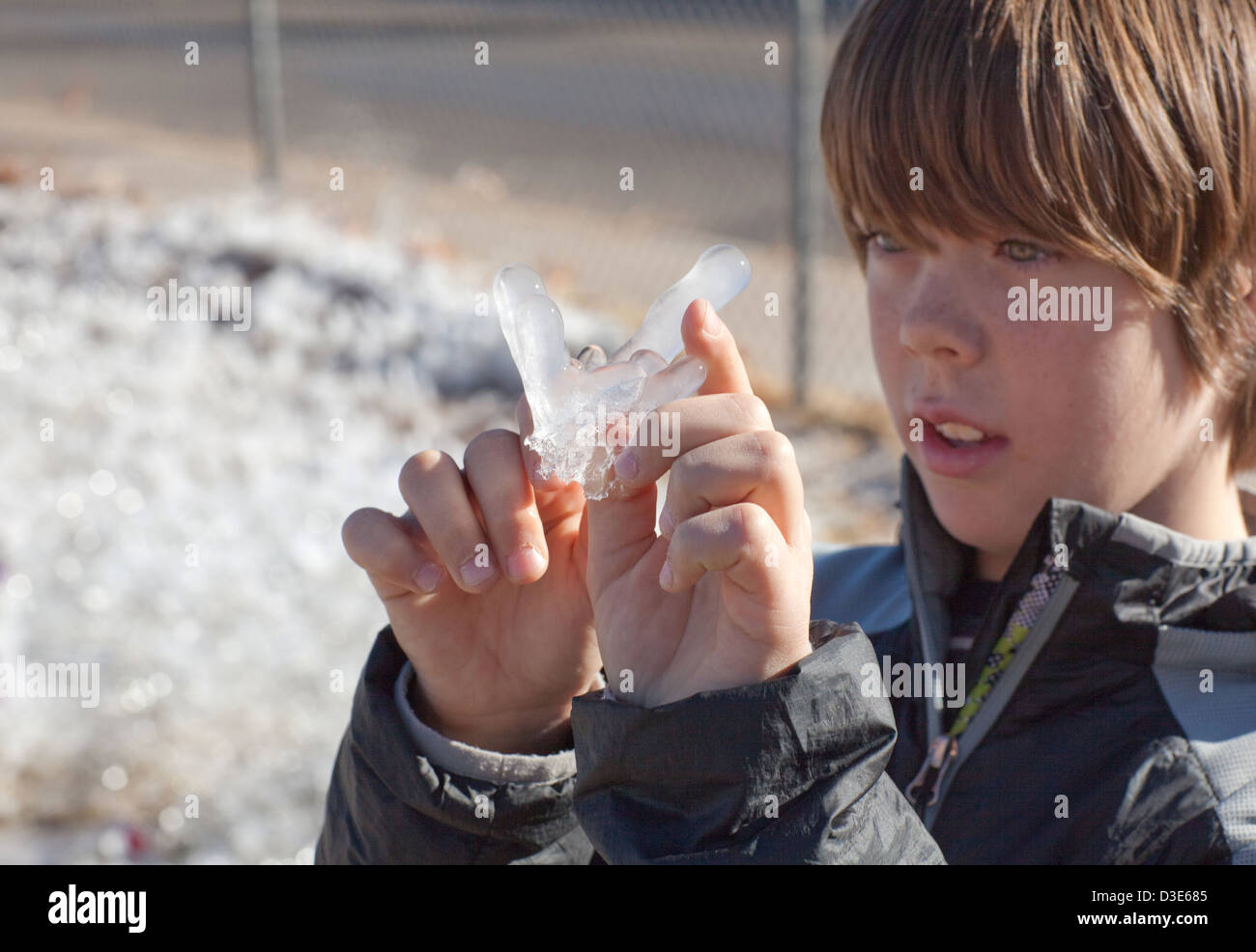 Ten year old boy examines an ice crystal. Stock Photo