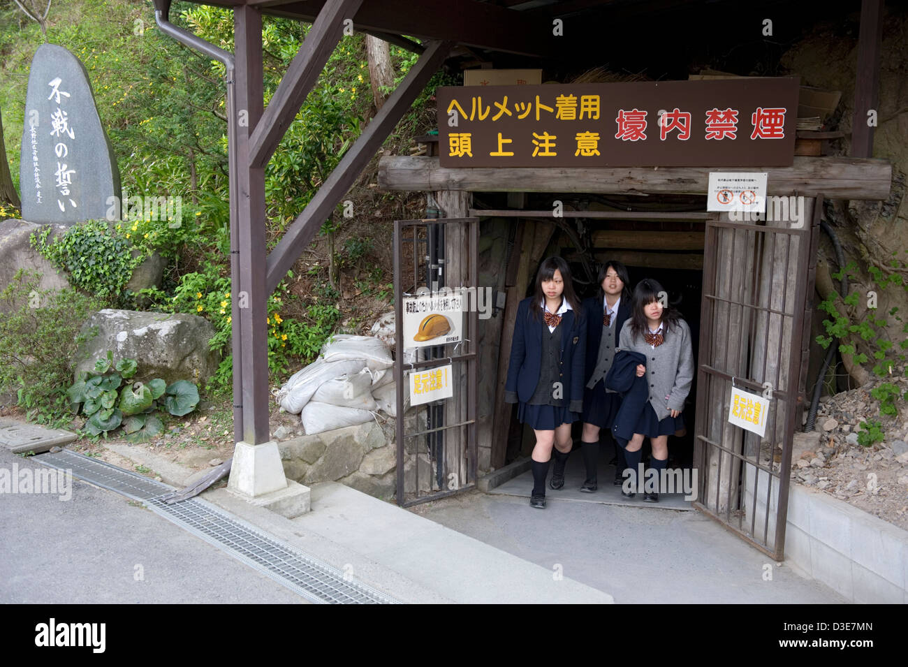 High school girls emerge from tunnel entrance to Matsushiro Daihonei Zozan Chikago World War 2 underground Imperial headquarters Stock Photo