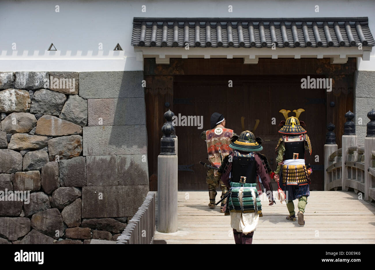 Samurai warriors wearing traditional armor crossing moat bridge at Akaganemon Gate during Odawara Hojo Godai Matsuri festival. Stock Photo