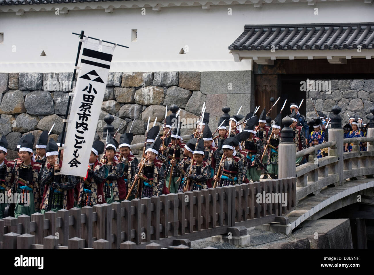 Samurai warriors wearing traditional costumes crossing moat bridge at Akaganemon Gate during Odawara Hojo Godai Matsuri festival Stock Photo