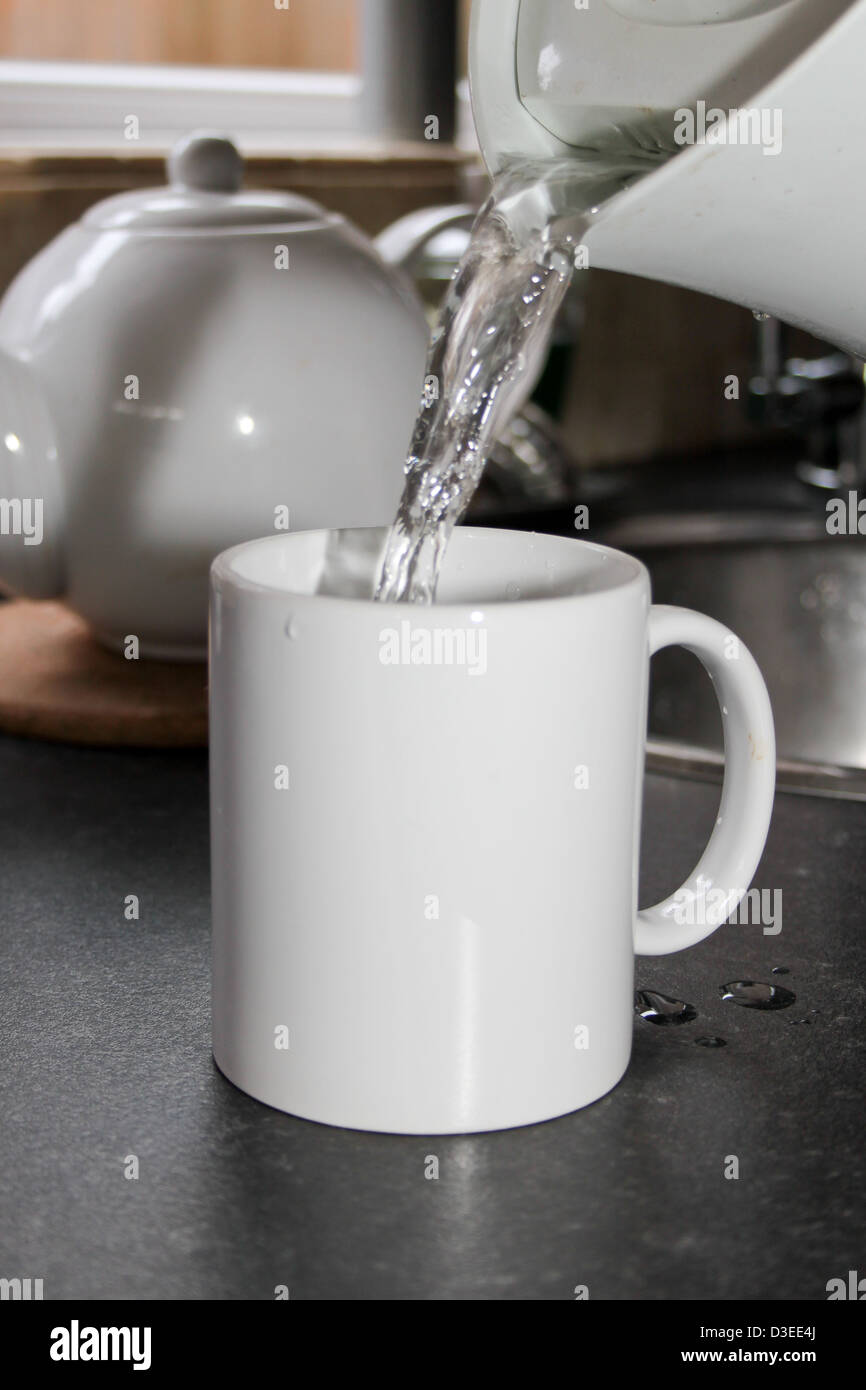 boiling water being poured from a kettle into a white mug Stock Photo -  Alamy