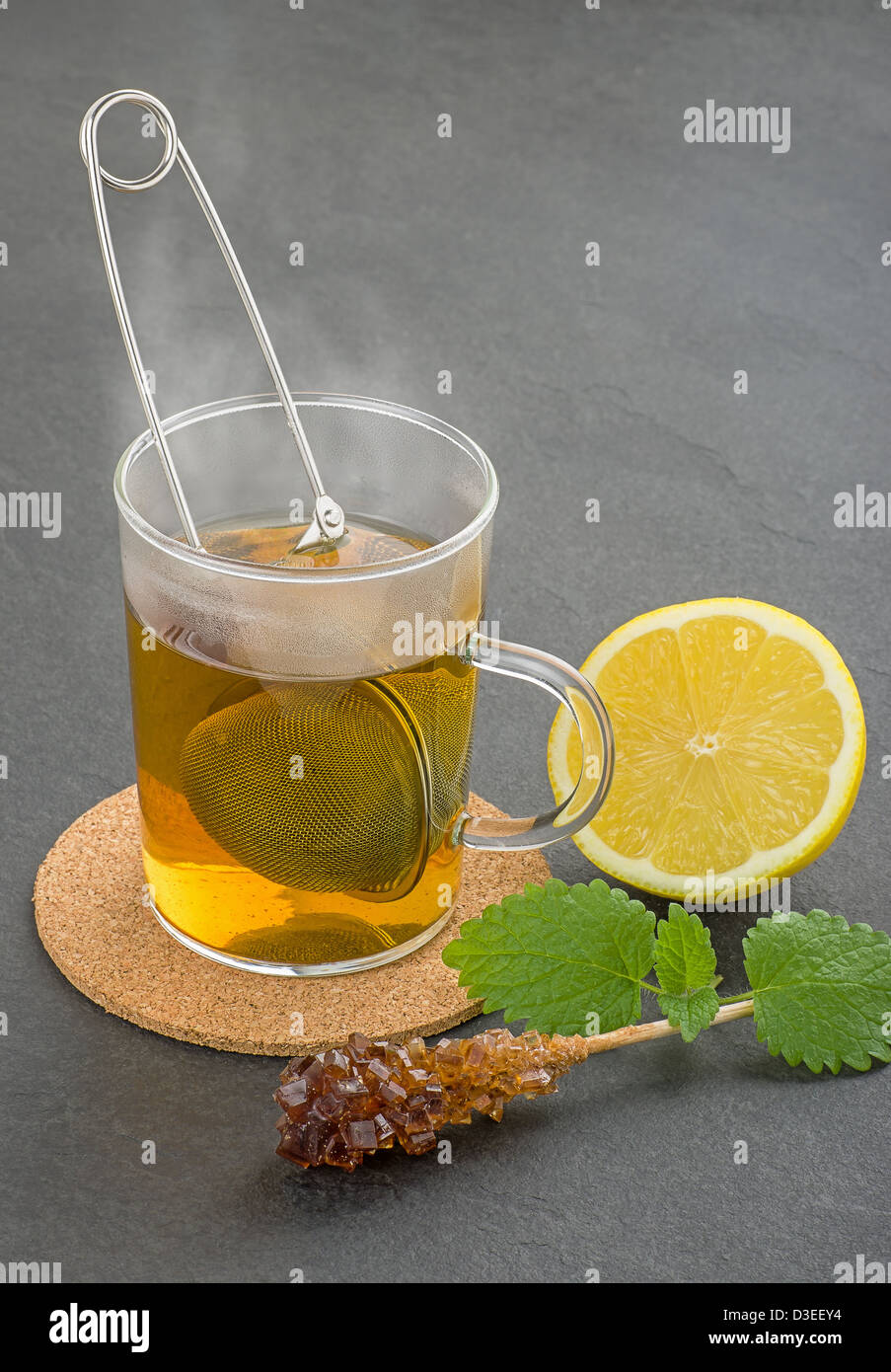 Steaming cup of tea with teastrainer on a slate plate Stock Photo