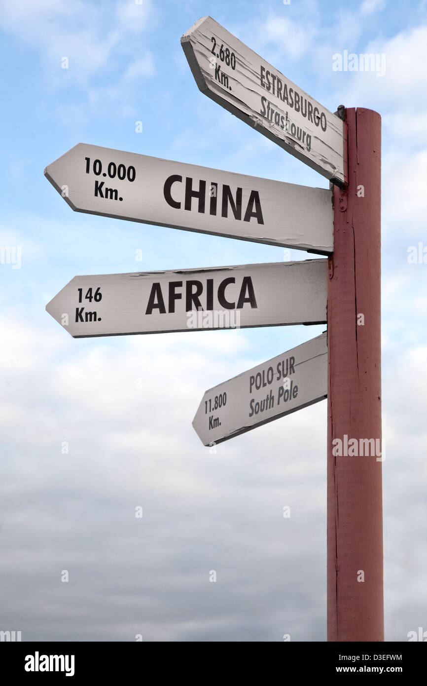 Crossroads sign indicating the distance to China, Africa North Pole and Strasbourg. Stock Photo