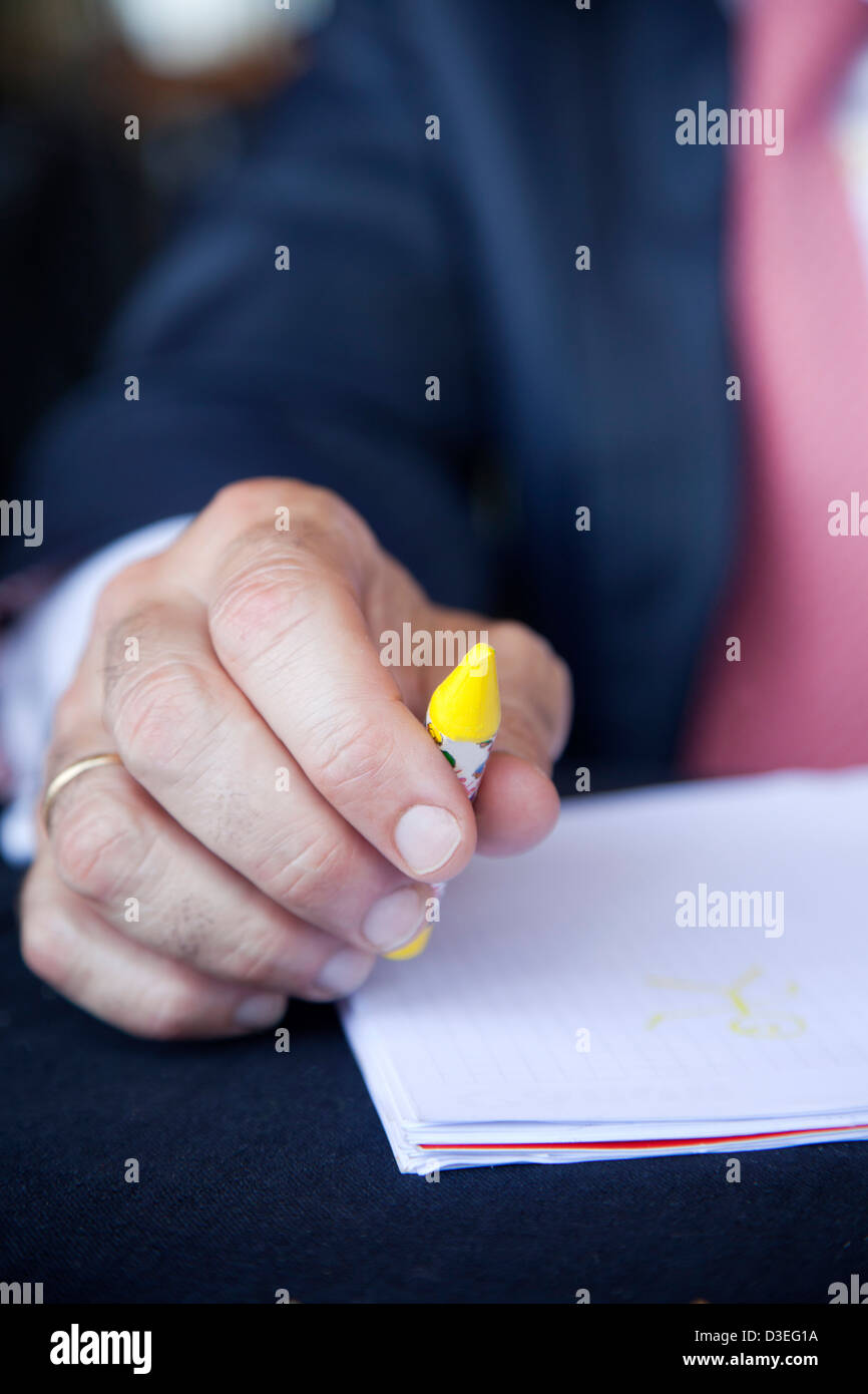 Businessman at at table ready to write with crayons Stock Photo