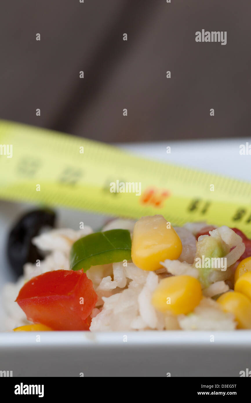 Healthy summer rice salad with tomato, onions, corn, pepers, black olives and avocate good for your diet. Stock Photo